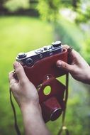 holding retro camera in red cover