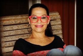 Smiling woman in red glasses on the bench