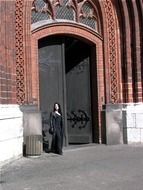 woman at gothic church door, germany, stralsund