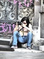 woman photographer near the gate with graffiti