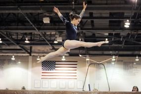gymnastics girl jumping high above the floor