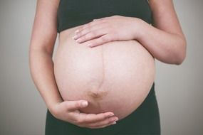 pregnant woman holding her big belly