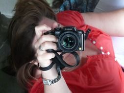 photo of a girl in a red blouse with a camera