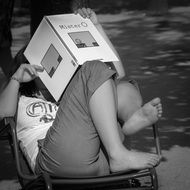 woman sits with feet on chair and reads book