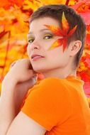 photo of a girl with a short haircut on the background of autumn leaves