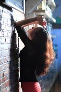 woman with beautiful long hair near the wall