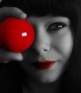 portrait of a beautiful woman with a red billiard ball in monochrome image