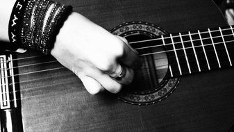 black and white photo of a playing hand on a guitar