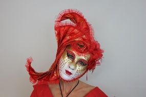 woman in carnival mask with red feathers