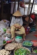 local woman sells vegetables in vietnam market