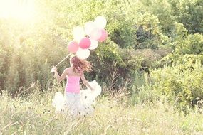 happy girl with balloons in nature