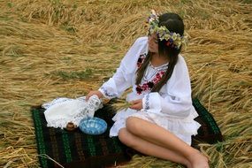 girl with a wreath on his head in traditional suit