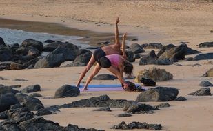 Women are doing yoga on the beach