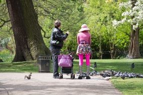 people feeding pigeon in park
