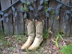 cowboy boots stand by the fence