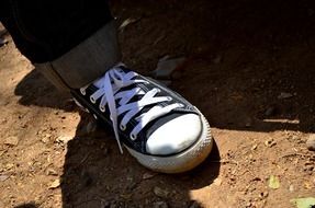 black shoe with white lacing on leg