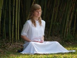 girl in white meditates among nature, thailand