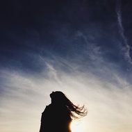 silhouette of a girl with long hair at sunset