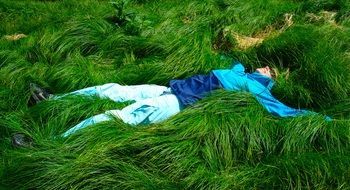woman lying on the thick green grass
