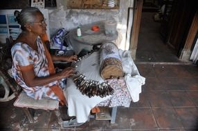 elderly woman embroiders tablecloths in Sri Lanka