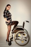 photo of the girl in a short dress next to a wheelchair