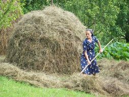 woman with pitchfork near hay