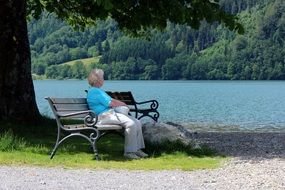 woman sitting on a bench by the lake