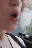 cloud of smoke near the female mouth