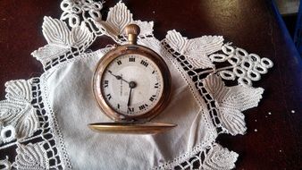 pocket vintage watch on white lace napkin