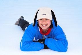 smiling girl lying on the snow