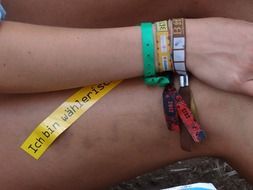 three colorful bracelets on her wrist