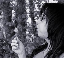 woman blowing a dandelion