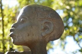 statue of an ancient woman with blurred background with the trees