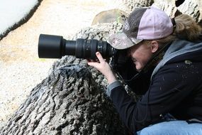 woman with a camera takes pictures outdoors