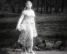 Black and white photo of the vintage statue of young girl with grapes
