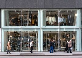 people on sidewalk at dkny store display