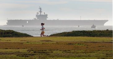 a woman runs along the coast