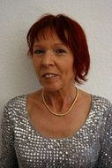 woman with a short haircut and red hair in a shiny sweater