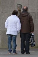 man and woman near statue