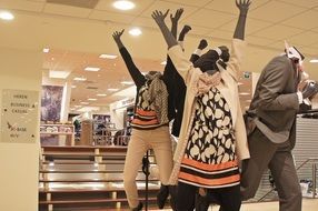 mannequins in a clothing store with arms raised