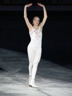 Woman skating on ice in a white suit
