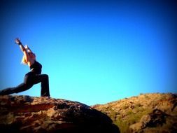 Woman doing yoga on a rock