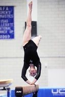 girl is doing exercise on gymnastics log