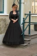 Woman is wearig a dress from Victorian time