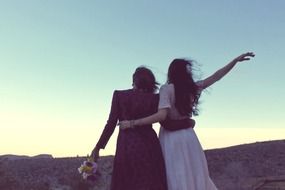 happy girlfriends together at sunset, back view