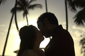 kiss of a couple in love on a sunset background