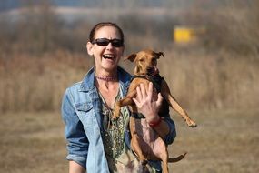 happy woman with a dog in her arms