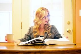 woman works with a book at the table