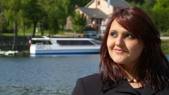 portrait of a girl on the background of a boat on the lake