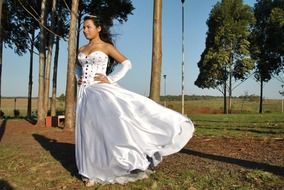 girl in white dress posing against the wind